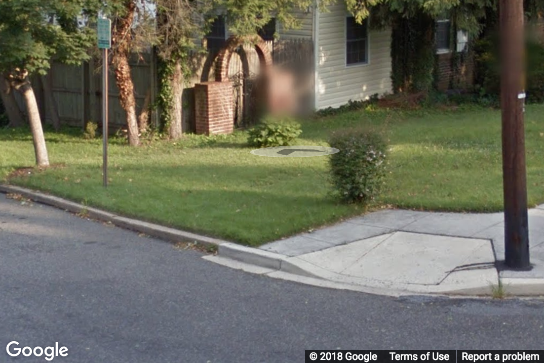 A StreetView image of an intersection missing a sidewalk from one direction